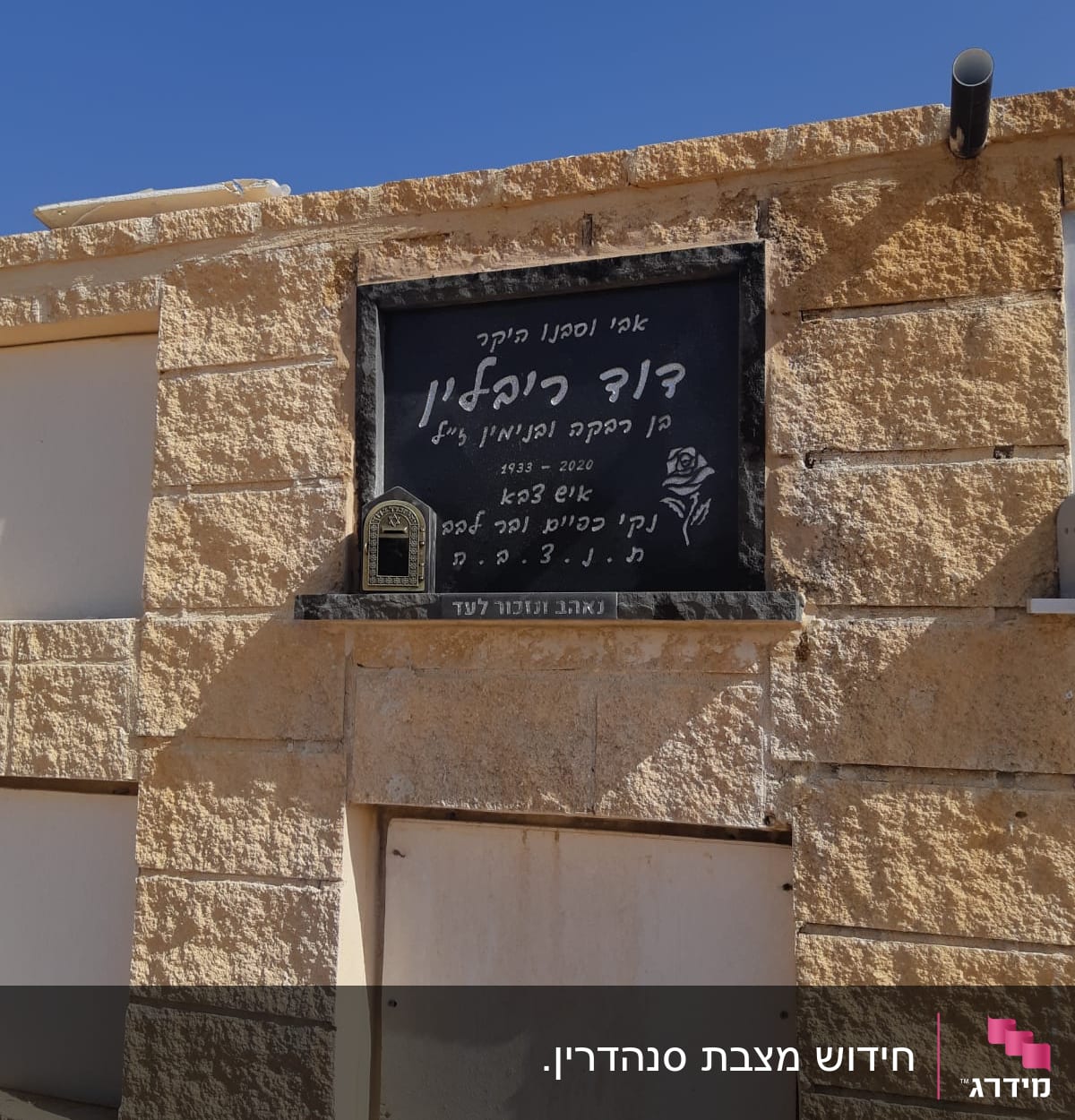 מצבה עם כיתוב בעברית ופרח חקוק